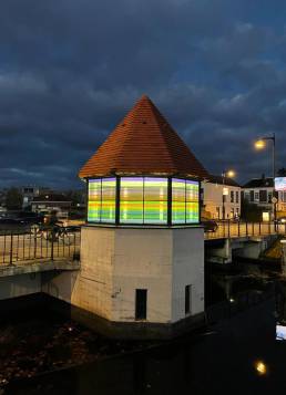 Brugwachtershuisje Apeldoorn verlicht met gekleurde transparante plakfolie als een lampion.