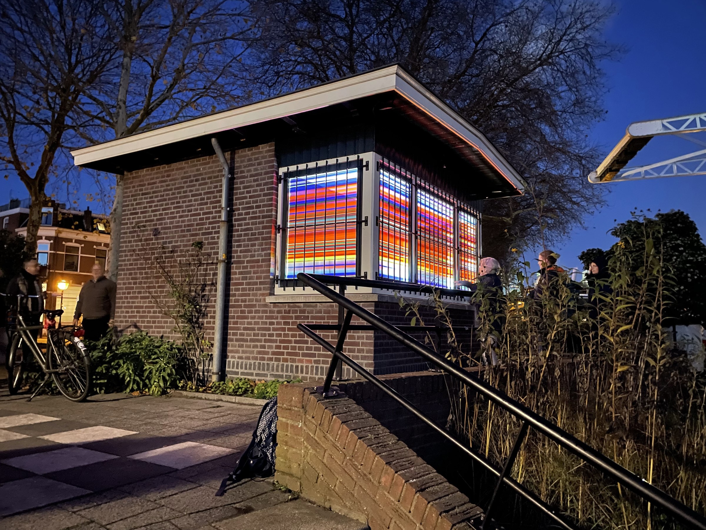 Brugwachtershuisje Utrecht verlicht met gekleurde transparante plakfolie als een lampion.