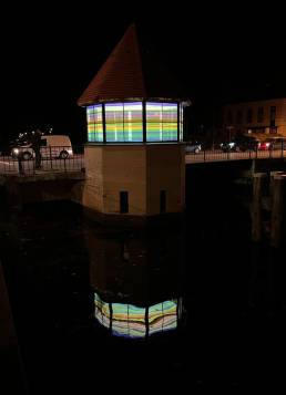 Brugwachtershuisje Apeldoorn verlicht met gekleurde transparante plakfolie als een lampion.
